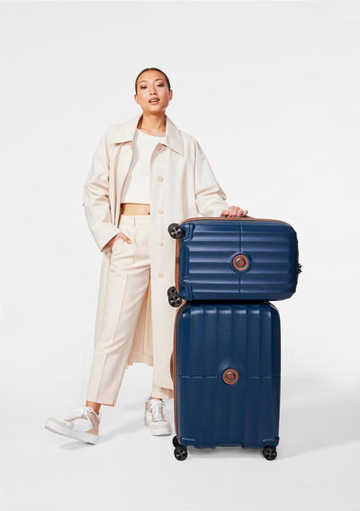 Delsey St. Tropez Luggage stacked on itself with young woman ready to travel